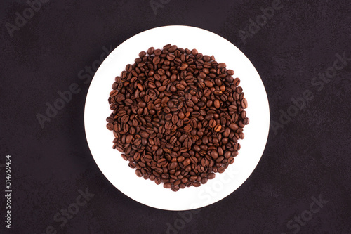 Grains of coffee on a white plate. View from above.