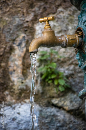 Golden tap pouring drinking water