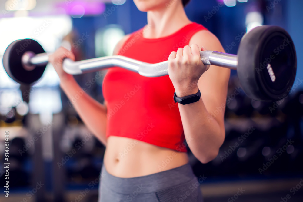 Woman in red top training bicep in gym. People, fitness and lifstyle concept Woman in red top training bicep in gym. People, fitness and lifstyle concept