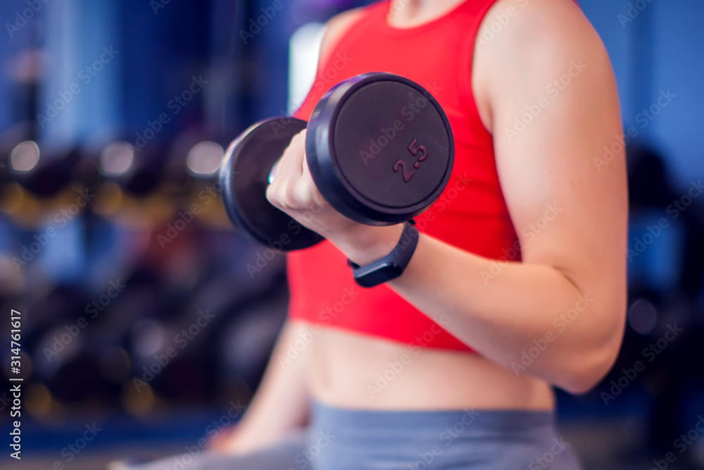 Woman in red top training bicep in gym. People, fitness and lifstyle concept Woman in red top training bicep in gym. People, fitness and lifstyle concept