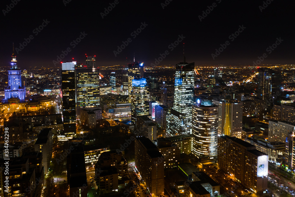 Beautiful aerial shot of the city of Warsaw. Poland. Drone flies over the city by the night lights of Warsaw. 10. December. 2019. Aerial view of the night city with skyscrapers and busy streets with 
