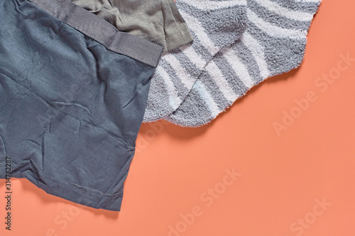 Striped soft and warm socks and new dark underpants on orange background. Space for text. Top view