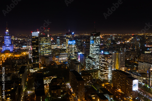 Beautiful aerial shot of the city of Warsaw. Poland. Drone flies over the city by the night lights of Warsaw. 10. December. 2019. Aerial view of the night city with skyscrapers and busy streets with 
