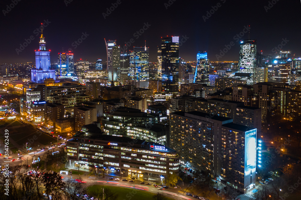 Warsaw, Poland. 03. December. 2019. Drone shot at night metropolis with skyscrapers and buildings. Aerial view of the business center at night in winter. Warsaw,