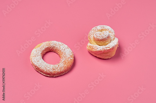 Wallpaper Mural One homemade baked bun in form of rose and donut powdered of sugar on pink background. Close-up Torontodigital.ca