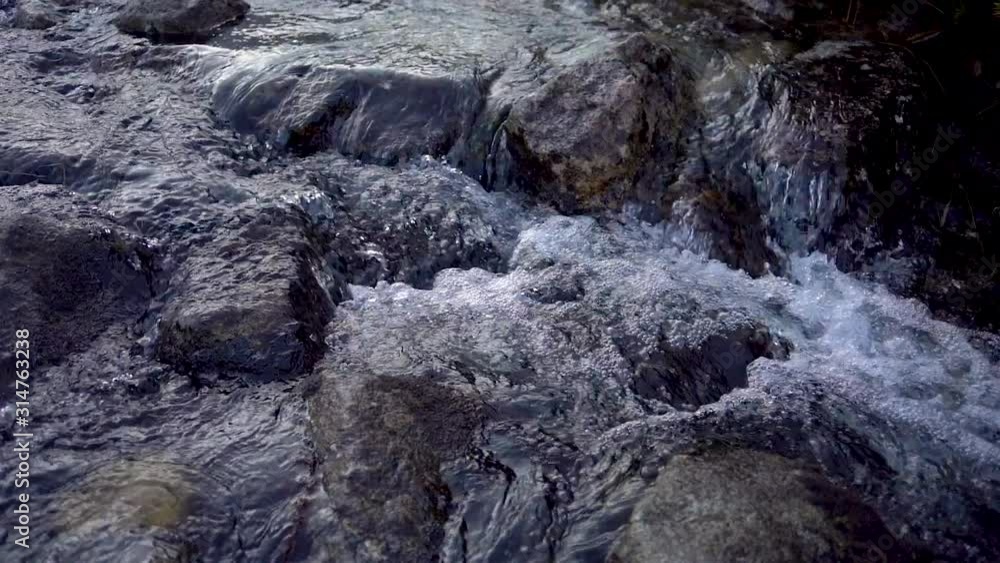 Fast flowing clear melting water in creek in mountain river at early spring Fast flowing clear melting water in creek in mountain river at early spring