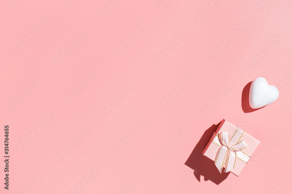 Pink gift box and white decorative hearts on pink background. Flat lay composition. Romantic, St Valentines Day concept Pink gift box and white decorative hearts on pink background. Flat lay composition. Romantic, St Valentines Day concept