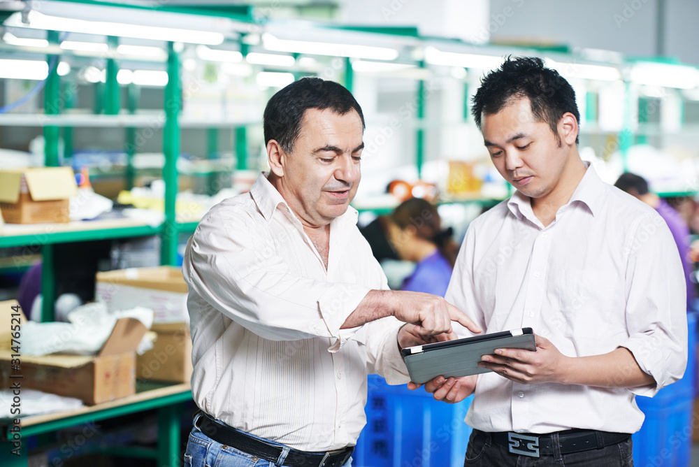Obraz premium manager and chinese worker in factory, Managing and cooperation