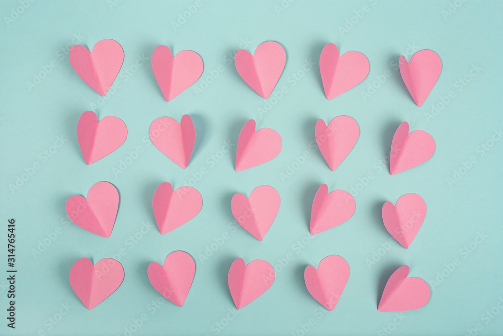 Pink paper hearts on mint background. Romantic concept. Flat lay.