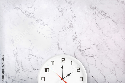 White wall clock on marble texture. Round white office clock on marble background