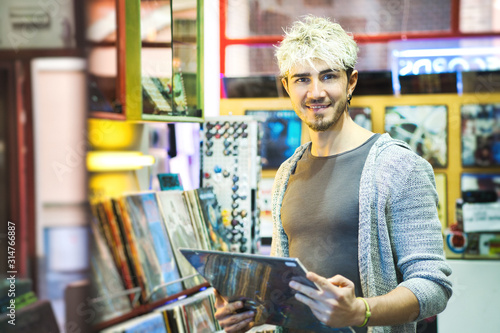 Young Man Choosing Vintage Vinyl LP In Records Shop