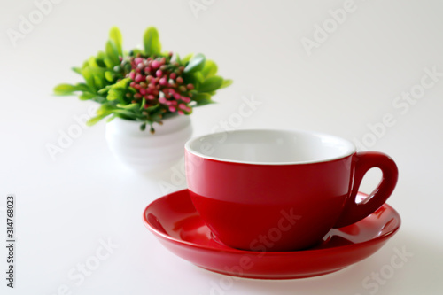 Red coffee cup and saucer isolated on white background.