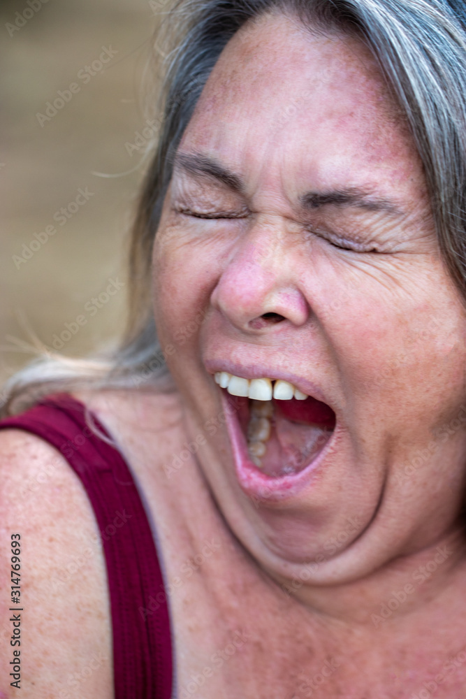 older woman with gray hair and age spots yawning outside older woman with gray hair and age spots yawning outside