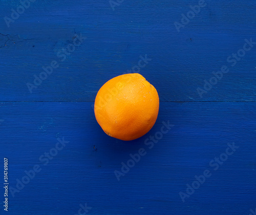 round orange on a dark blue background from boards painted in blue trend color