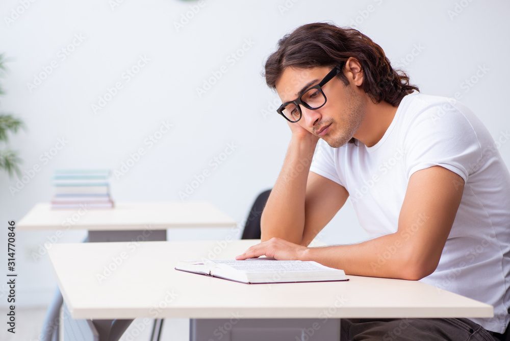 Young male student sitting in the classroom Young male student sitting in the classroom