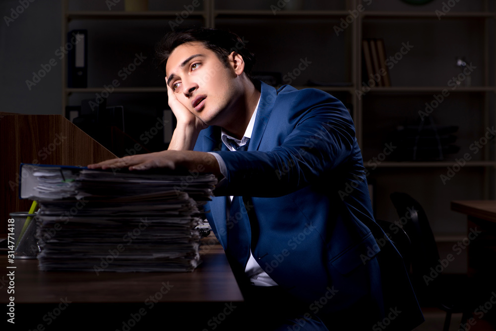 Young male employee working night in the office Young male employee working night in the office