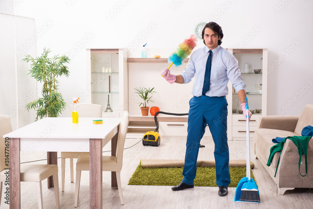 Young businessman cleaning the house Young businessman cleaning the house