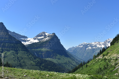 Lush Green Valley and Waterfall Surrounded by Snow Dusted Mountains, Going-to-the-Sun Road, Glacier National Park, Montana