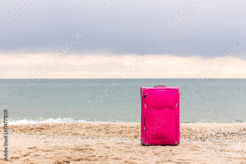 suitcase on the beach and on the background of the sea with copy space