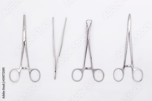 Metal surgical instruments on white background. Flat lay. Top view