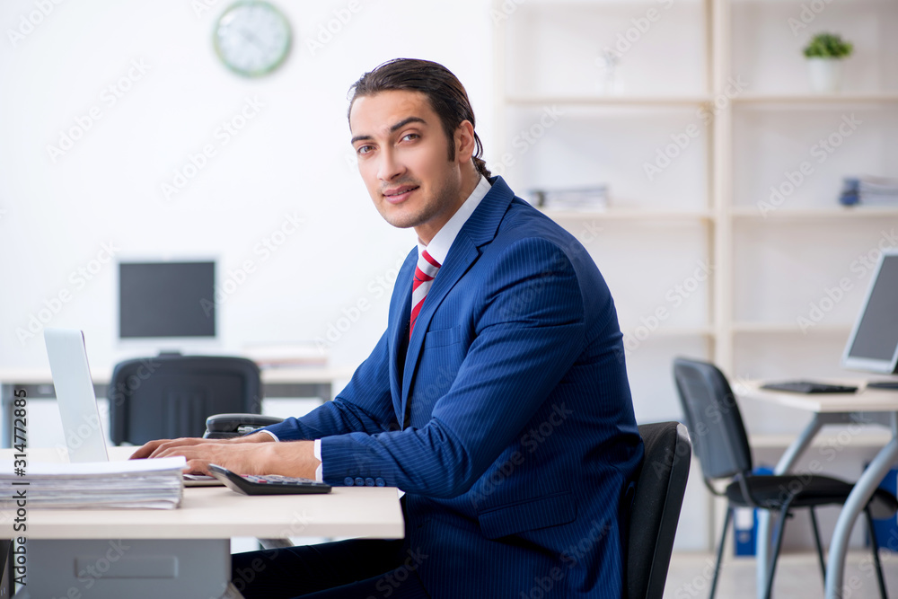 Young male businessman sitting in the office Young male businessman sitting in the office