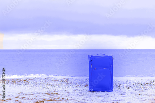 uitcase in the sand and seascape