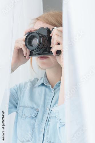 Young woman taking photos secretly through the window photo