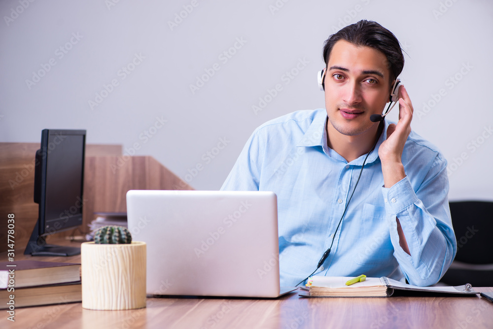 Call center operator working at his desk Call center operator working at his desk