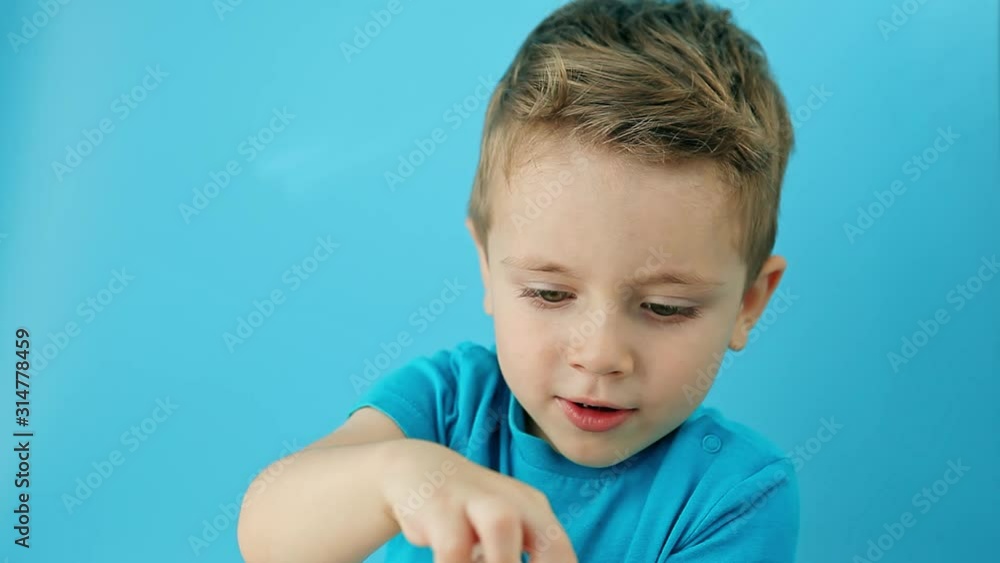 Little child taking pill on blue background. Household danger. Woman health and health care Little child taking pill on blue background. Household danger. Woman health and health care