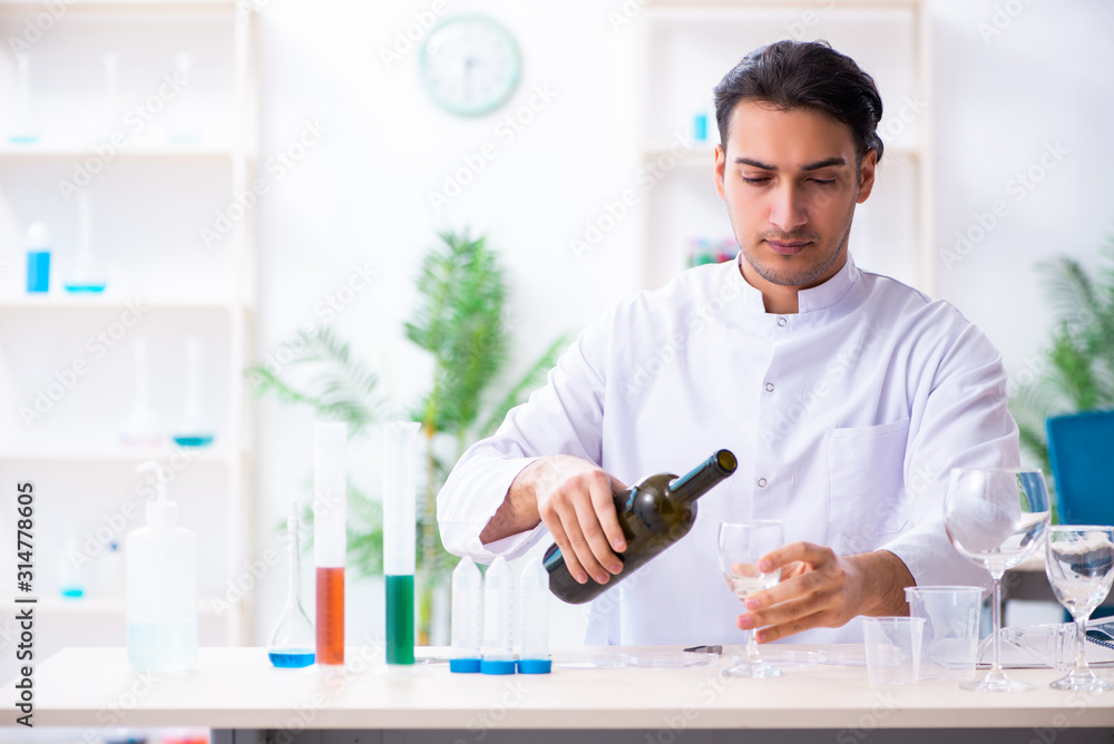 Male chemist examining wine samples at lab Male chemist examining wine samples at lab