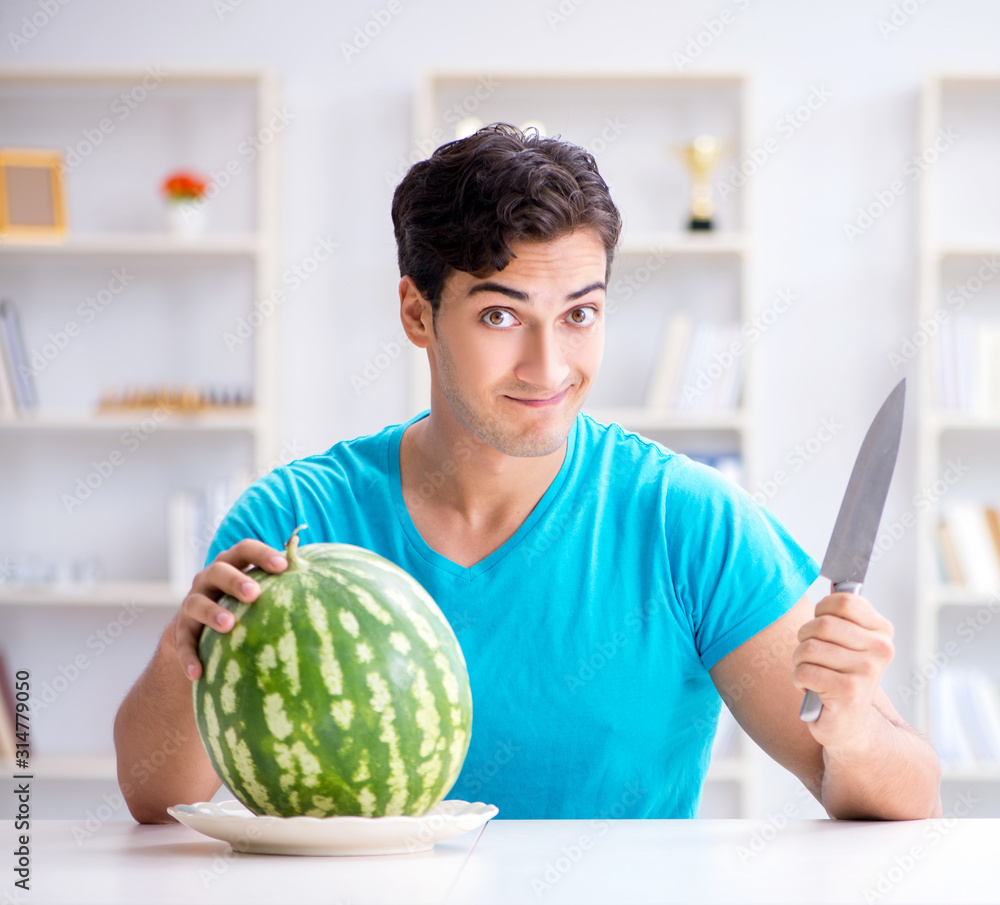 Fototapeta premium Man eating watermelon at home