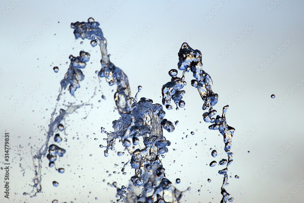 Drops of a falling water fountain against the evening sky. natural textures and backgrounds Drops of a falling water fountain against the evening sky. natural textures and backgrounds
