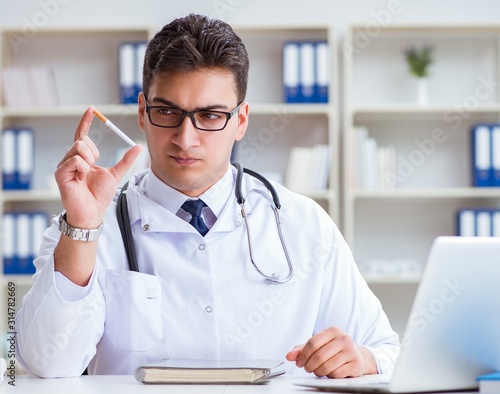 Male doctor in anti-smoking conceptwithcigarette pack