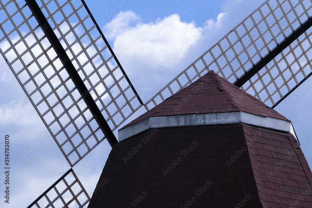 Windmill in the flower garden cloud and blue sky Windmill in the flower garden cloud and blue sky