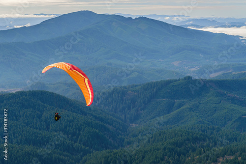 Paraglider flies over the Oregon Coast Range.