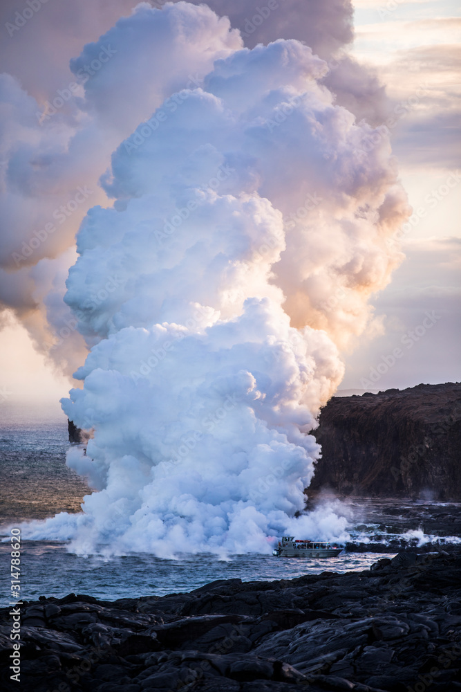 Fototapeta premium Lava pouring into the sea causing steam clouds