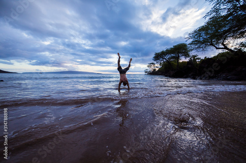 Man doing handstand on hawaii beach