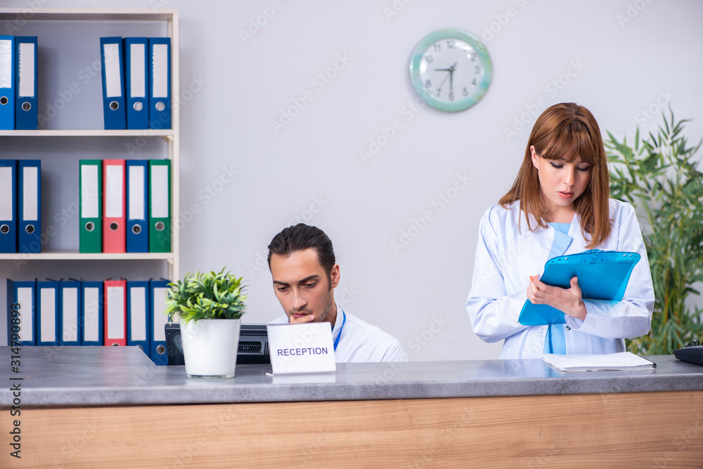 Two doctors working at the reception in the hospital