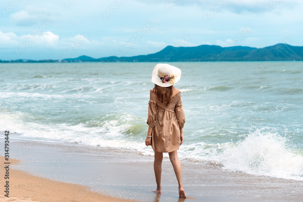 Young asian tourist woman walk and relax on the beach. Young asian tourist woman walk and relax on the beach.