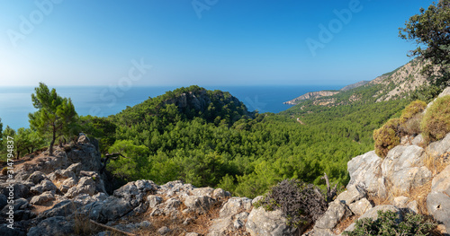 Beautiful turkish seascape with green pine forest on the coast and rocky mountains.