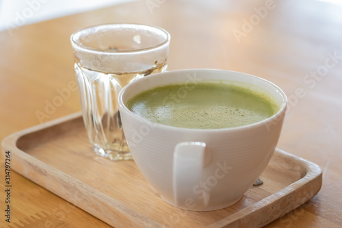 hot matcha green tea latte on wooden table. 