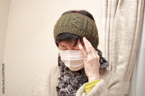 middle aged woman wearing a mask and catching a cold