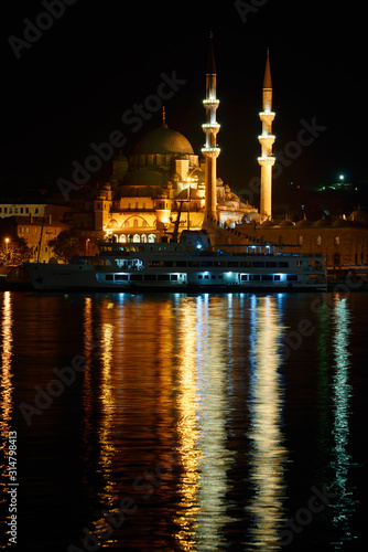The New Mosque in early morning before sunrise with lights reflected in the Golden Horn Istanbul