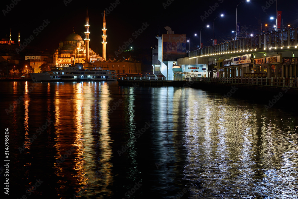 The New Mosque in early morning with fishermen on the Galata bridge over the Golden Horn Istanbul The New Mosque in early morning with fishermen on the Galata bridge over the Golden Horn Istanbul
