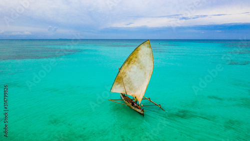 Aerial view of Fishermen on a sailing Pirogue departing Nosy Iranja in Madagascar