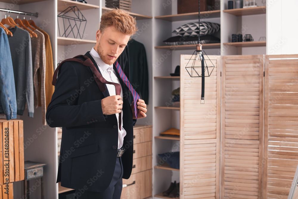 Handsome man choosing necktie in dressing room Handsome man choosing necktie in dressing room