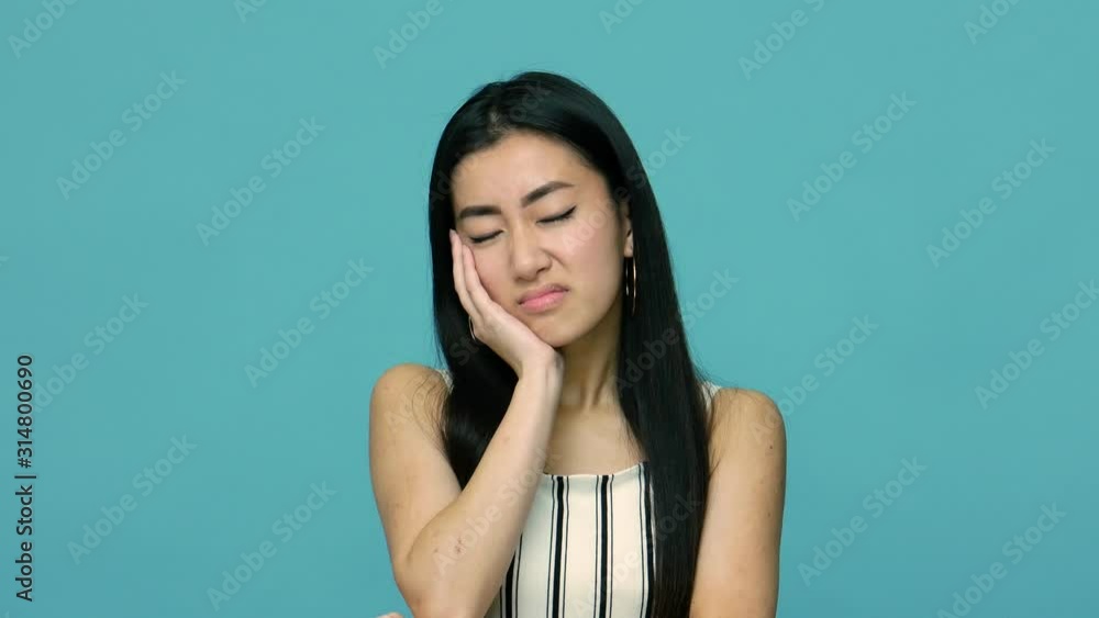 I am bored! Depressed asian woman with long black hair leaning on hand and looking at camera with dull indifferent expression, listening to boring tedious story. indoor studio shot, blue background I am bored! Depressed asian woman with long black hair leaning on hand and looking at camera with dull indifferent expression, listening to boring tedious story. indoor studio shot, blue background