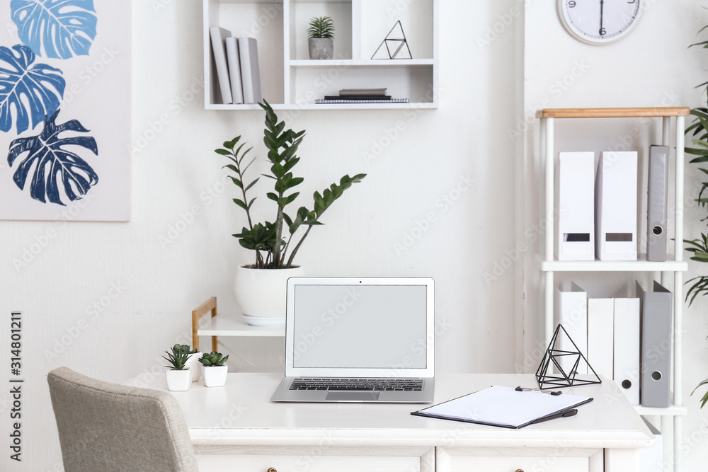 Stylish comfortable workplace with laptop in modern room