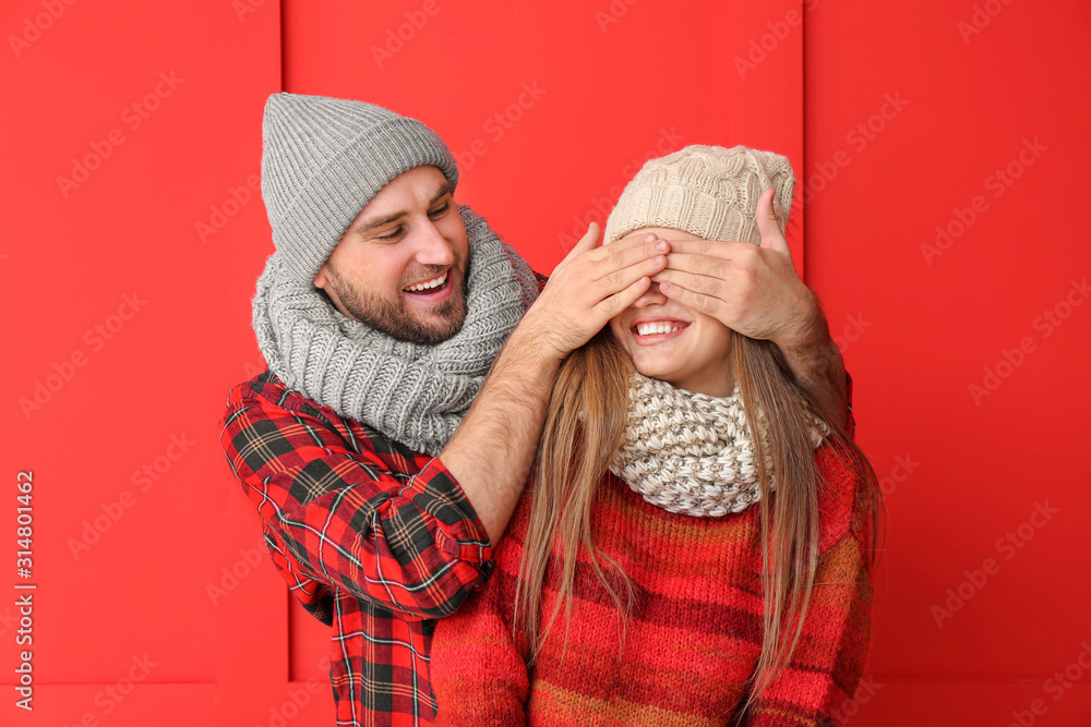 Happy man covering eyes of his girlfriend against color background Happy man covering eyes of his girlfriend against color background