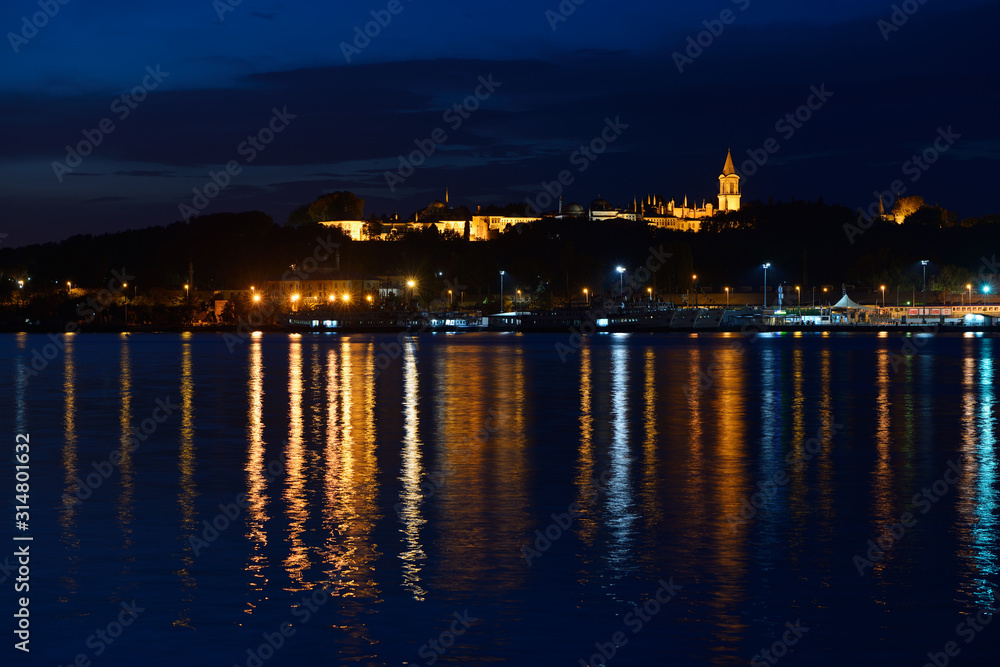 Topkapi Palace at early morning twilight with lights reflected in the Golden Horn Istanbul